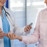 doctor-checking-glucose-level-in-diabetic-patient-F84BKZZ
